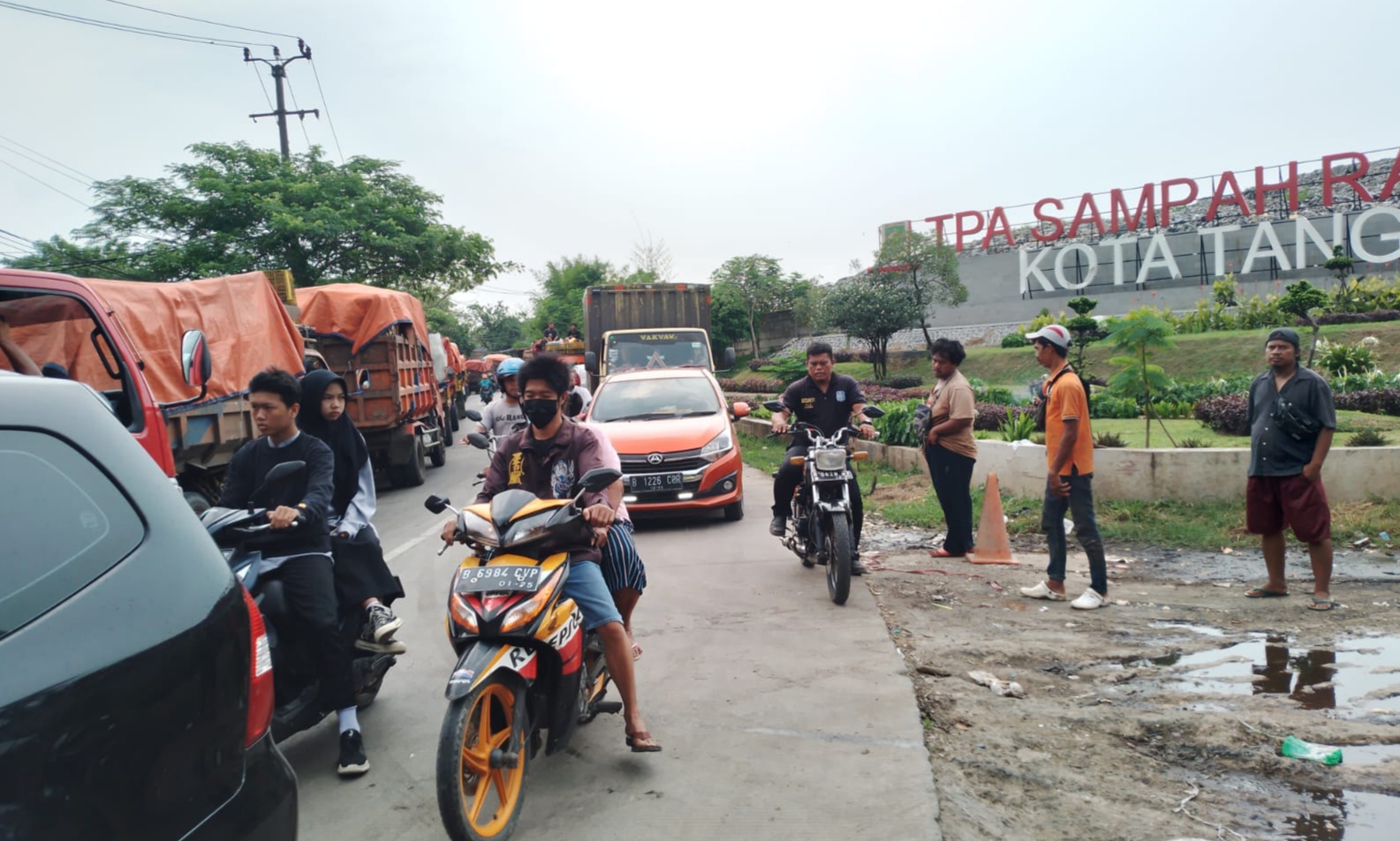 Suasana jalan raya di sekitar TPA Rawa Kucing tersendat karena puluhan truk sampah parkir di sisi jalan tersebut