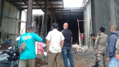 Petugas Satpol PP Kota Tangsel sedang menyengel pembangunan pabrik masker yang tak berizin