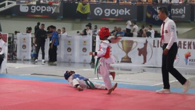 Dua atlet cilik saling adu teknik dalam pertandingan Liga Taekwondo Pelajar Indonesia 2025 di GOR Indoor Kelapa Dua, Tangerang.
