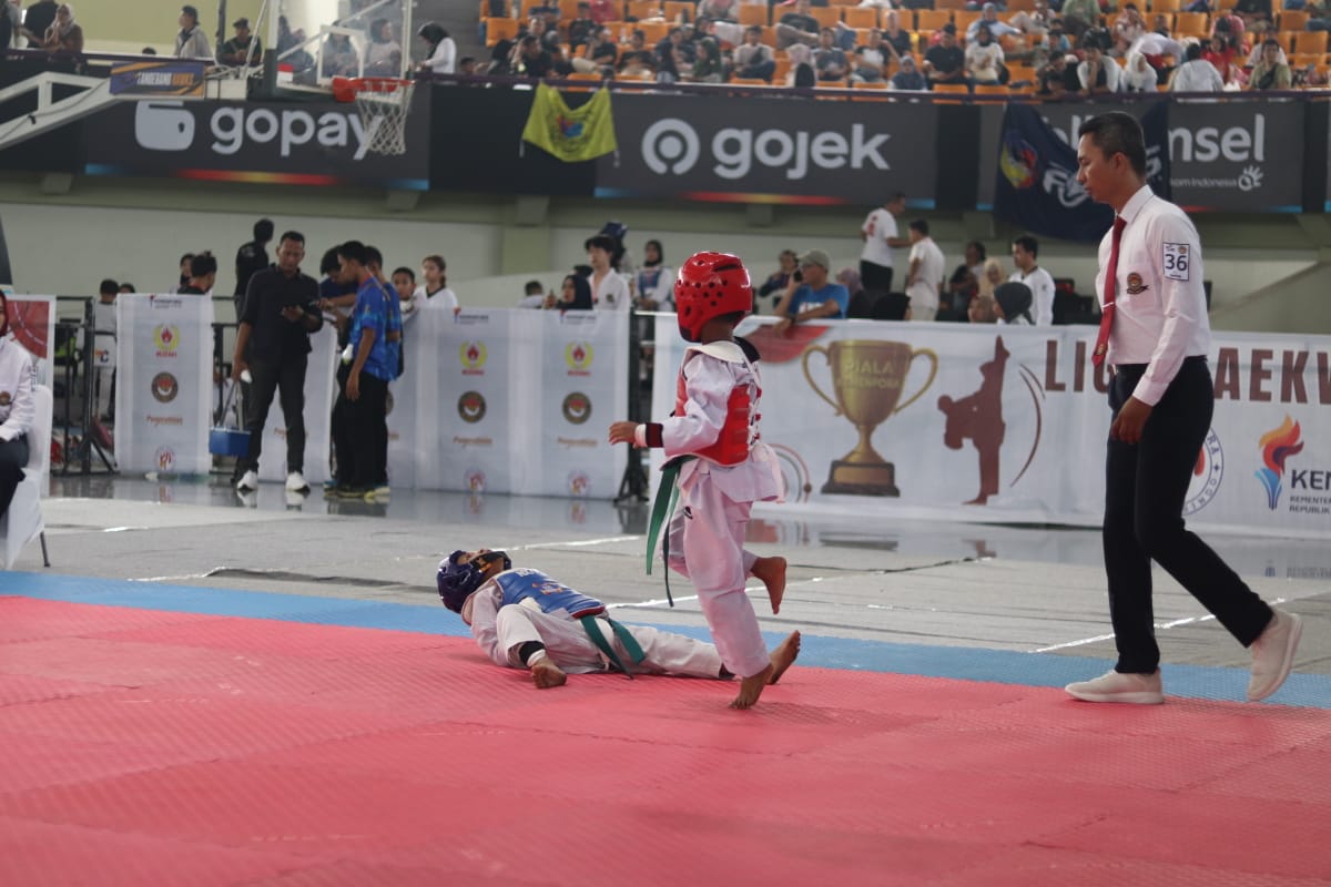 Dua atlet cilik saling adu teknik dalam pertandingan Liga Taekwondo Pelajar Indonesia 2025 di GOR Indoor Kelapa Dua, Tangerang.
