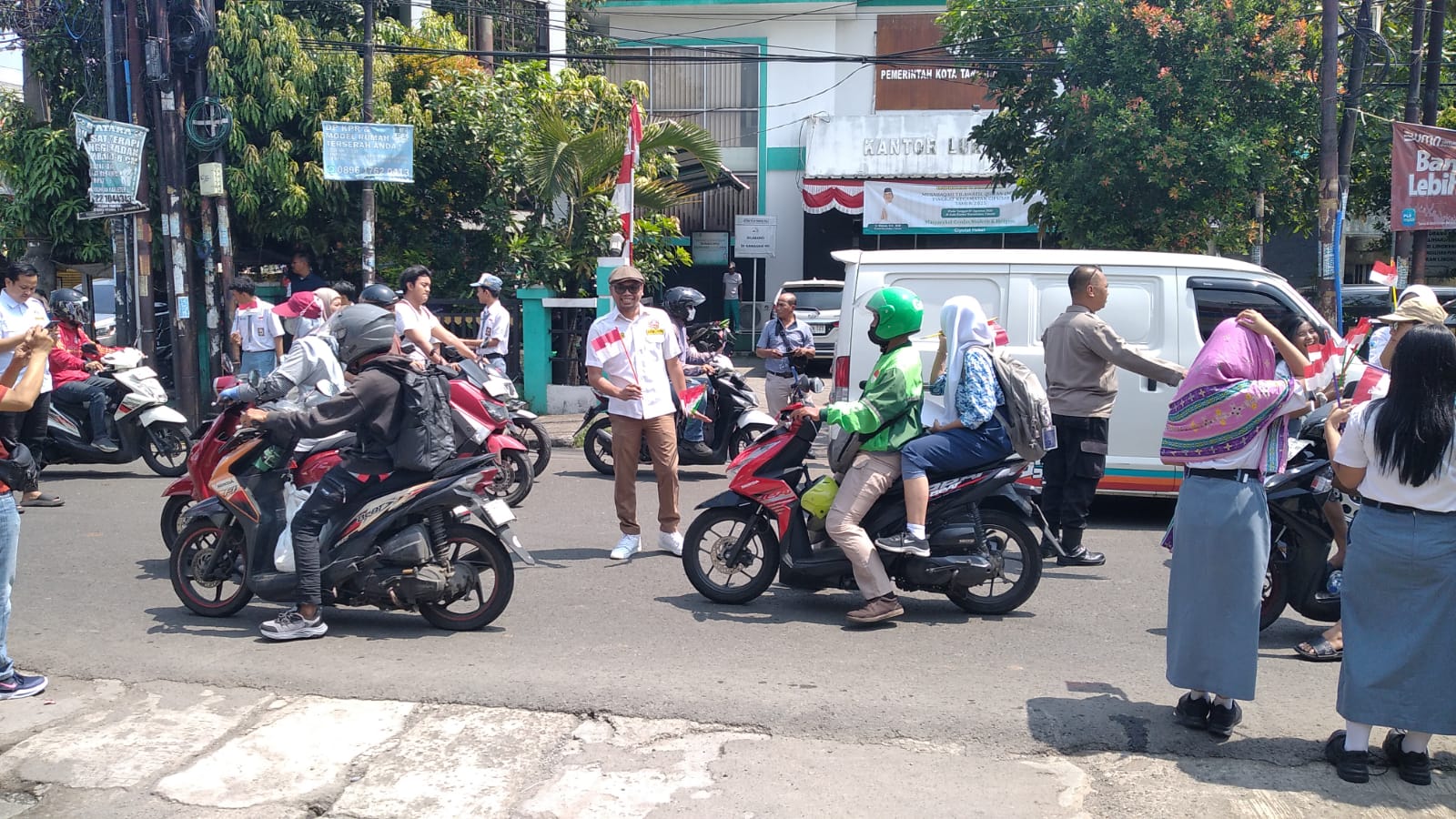 Brimob Banten, Karang Taruna Tangsel, dan pelajar SMAN 1 Ciputat bagikan ribuan bendera untuk kobarkan semangat kemerdekaan.